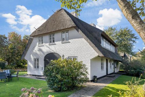 an old white house with a thatched roof at Dohlenhof Das Scheunentor in Keitum