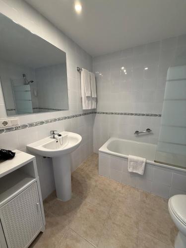 a bathroom with a sink and a tub and a toilet at Kingfisher Apartments Benal Beach in Benalmádena