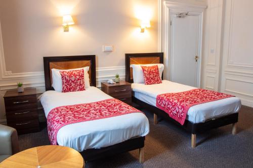 a hotel room with two beds and a table at Adelphi Hotel in Liverpool