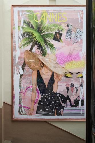 a poster of a woman with a hat on a wall at Le XV Cannes in Cannes