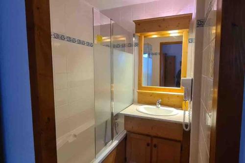 une salle de bain avec un lavabo et une douche avec un miroir dans l'établissement Appartement 4 ou 5 pers ambiance montagne, à Oz