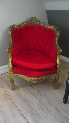 a red chair sitting on top of a wooden floor at The Garden Hill Hotel in Vallåkra