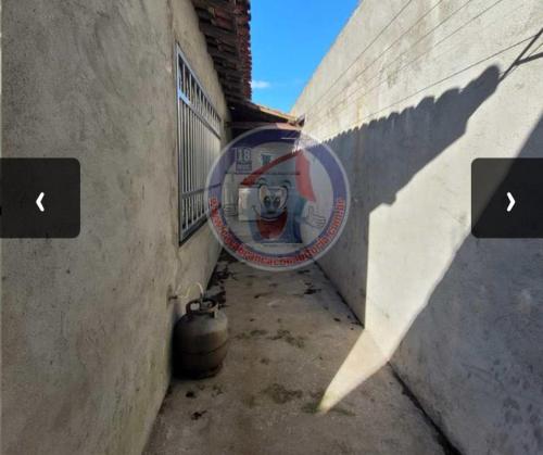 an alley with a sign on the side of a building at Casa pé na areia a 100 metros da praia in Mongaguá