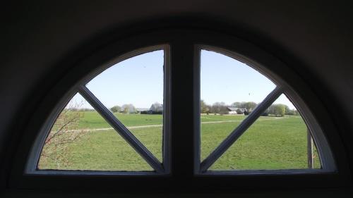 an arched window with a view of a field at The Garden Hill Hotel in Vallåkra