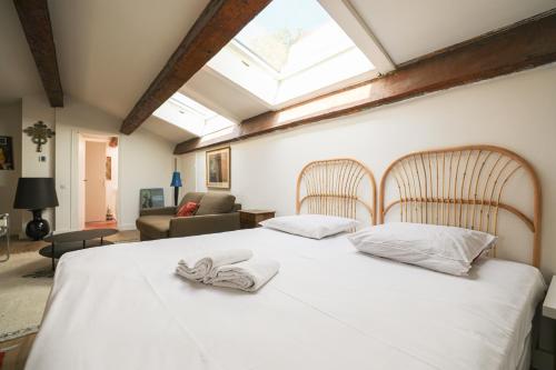 ein Schlafzimmer mit einem weißen Bett mit zwei Handtüchern darauf in der Unterkunft Bastide les Oréades - Marseille in Marseille