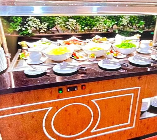 a buffet line with bowls and plates of food at Tolip Olympic International City in New cairo