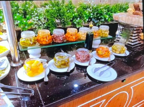a buffet with many jars of food on a counter at Tolip Olympic International City in New cairo