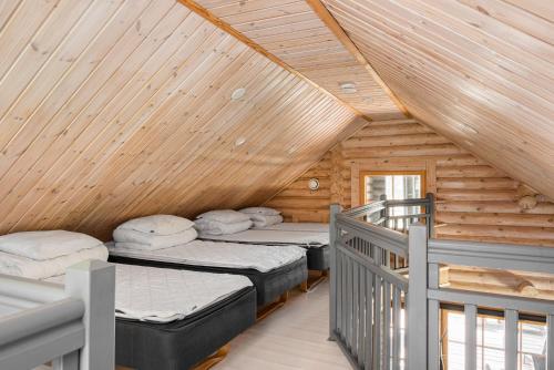 a room with two beds in a wooden cabin at Yyteri Beach Lomakeskus, Havulinna 28 in Pori