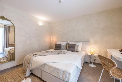a bedroom with a large white bed and a mirror at Hotel Aria in Podstrana