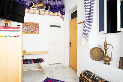 a room with white walls and a door and a rug at RIAD AMR in Tangier