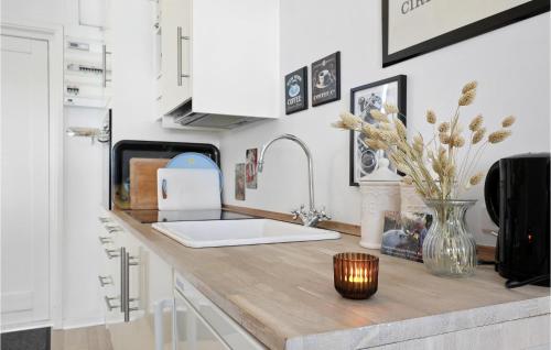 a kitchen counter with a vase of flowers on it at Beautiful Apartment In Nexø in Neksø