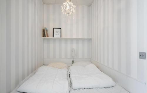 a white room with a bed with a chandelier at Beautiful Apartment In Nexø in Neksø