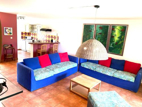 a living room with a blue couch and a table at Marisol les pieds dans l eau in Le Gosier