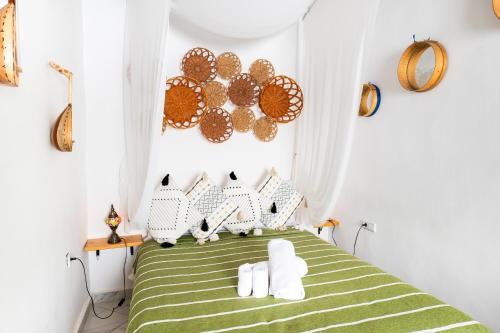 a bedroom with a green bed with white pillows at RIAD AMR in Tangier