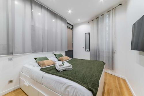 une chambre avec un grand lit avec une couverture verte dans l'établissement Appartement lumineux vaugirard a Paris 15 - 2P - FLAT-GUEST, à Paris