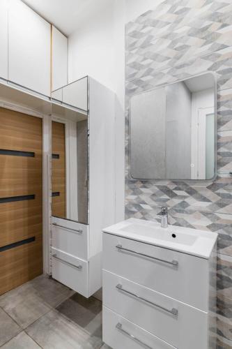 une salle de bain avec un lavabo et un miroir dans l'établissement Appartement lumineux vaugirard a Paris 15 - 2P - FLAT-GUEST, à Paris