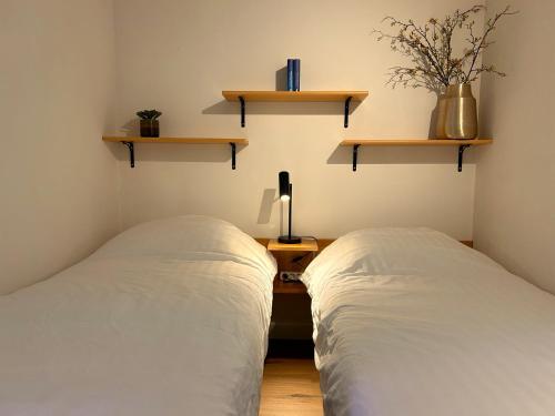 two beds in a room with shelves on the wall at Appartement 413 Kunners Oostenrijk in Mittelberg