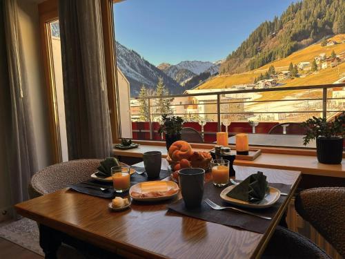 a table with food and a view of a mountain at Appartement 413 Kunners Oostenrijk in Mittelberg