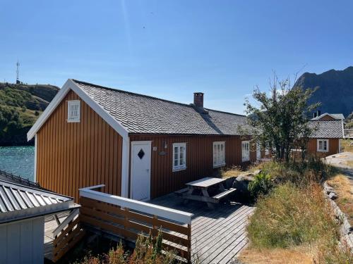 a red building with a deck and a house at Sakrisøy Rorbuer in Reine