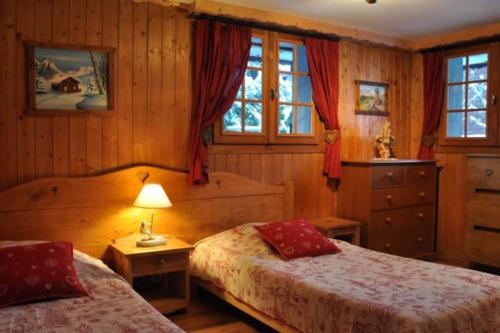 - une chambre avec 2 lits, une lampe et des fenêtres dans l'établissement Le Petit Liseron, à Morzine