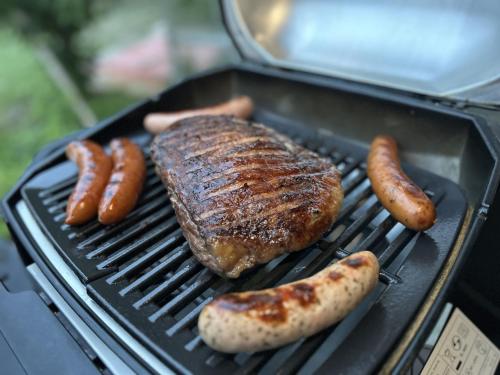 a grill with meat and sausages on it at 【 円 madoka 】逗子鎌倉で暮らすように過ごす一棟貸し宿泊施設​ in Zushi