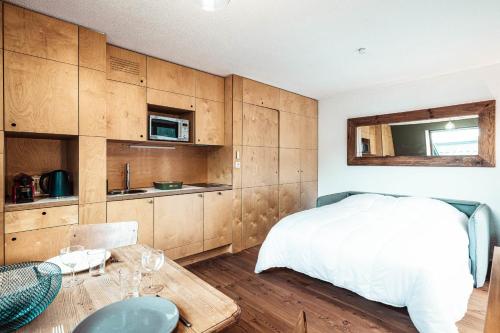 une chambre avec un lit et une table et une cuisine dans l'établissement Vertice - Center Chamonix Mont-Blanc View, à Chamonix-Mont-Blanc