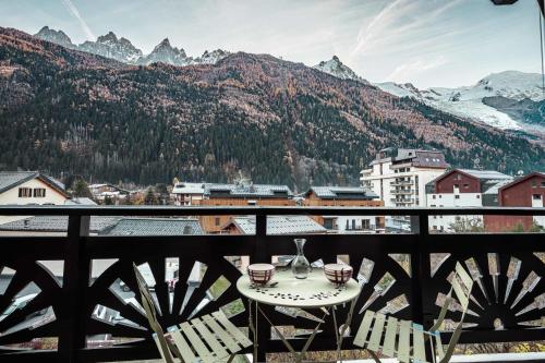 d'une table et de chaises sur un balcon avec vue sur les montagnes. dans l'établissement Vertice - Center Chamonix Mont-Blanc View, à Chamonix-Mont-Blanc