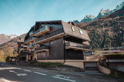 un bâtiment sur le côté d'une route avec des montagnes dans l'établissement Vertice - Center Chamonix Mont-Blanc View, à Chamonix-Mont-Blanc