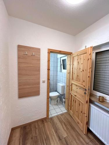 ein Badezimmer mit Toilette und Fenster in der Unterkunft Wiehenkrug in Lübbecke
