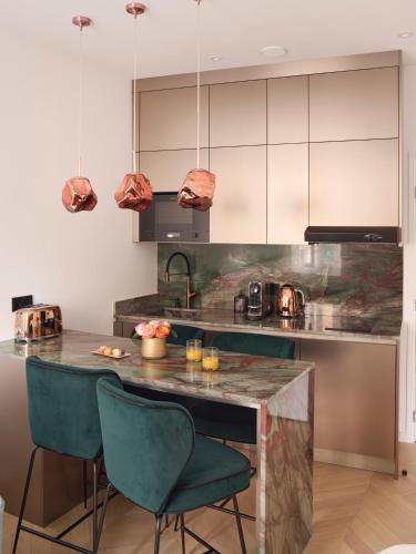 a kitchen with a counter and some chairs in it at Le XV Cannes in Cannes