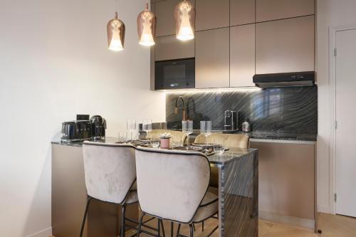 a kitchen with a counter with stools at a bar at Le XV Cannes in Cannes