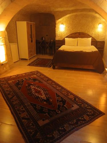 a bedroom with a bed and a rug on the floor at akile ablanın evi in Urgup