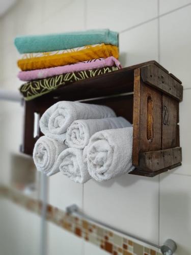 a pile of towels on a shelf in a bathroom at Casa de Praia Muito Aconchegante in Santos