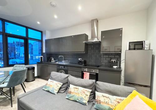 Una sala de estar con un sofá y una cocina. en The Copperfield Apartment - Broadstairs Central - By Goldex Coastal Breaks, en Broadstairs