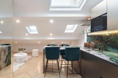 a kitchen with a sink and a counter with two stools at Le XV Cannes in Cannes
