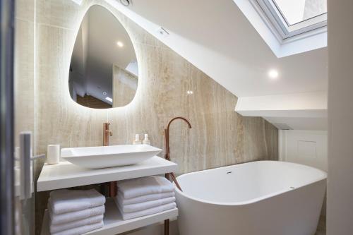 a bathroom with a sink and a tub and a mirror at Le XV Cannes in Cannes