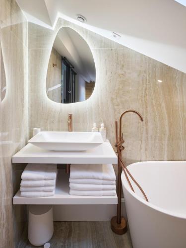 a bathroom with a tub and a sink and a mirror at Le XV Cannes in Cannes