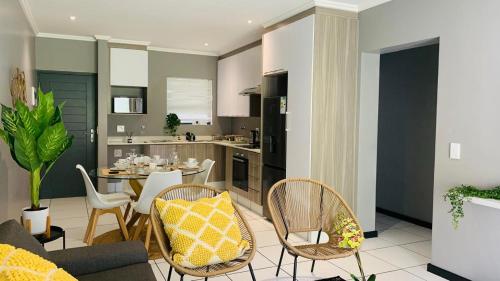 a kitchen and living room with a table and chairs at The Bridge at Ventura Estates in Sandton
