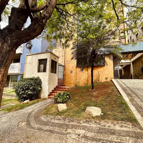 a house with a tree in front of it at Apê Letícia I Ar condicionado, wifi e garagem na Zona Sul de BH in Belo Horizonte