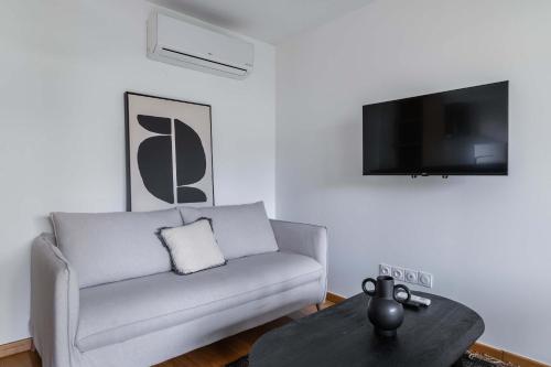 un salon avec un canapé et une table dans l'établissement Appartement lumineux avec terrasse Courbevoie - 4P - FLAT-GUEST, à Courbevoie