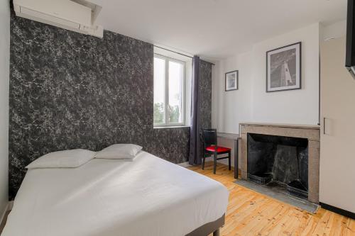 - une chambre avec un lit blanc et une cheminée dans l'établissement Le Hamburg - Les appartements de l'olivier, à Loyettes