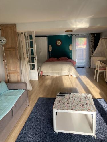 un salon avec un lit et un canapé dans l'établissement 30mn de Paris st lazare en train, studio 42 m2, à Verneuil-sur-Seine