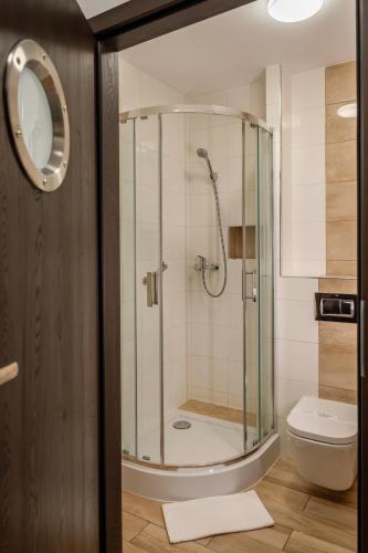 a bathroom with a shower and a toilet at Hotel Dworski Galaktyczny Park in Szczecin