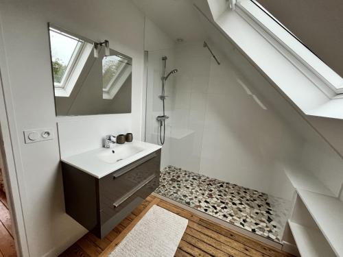 une salle de bain avec un lavabo et une douche sous l'escalier dans l'établissement Six hetres, à Varengeville-sur-Mer