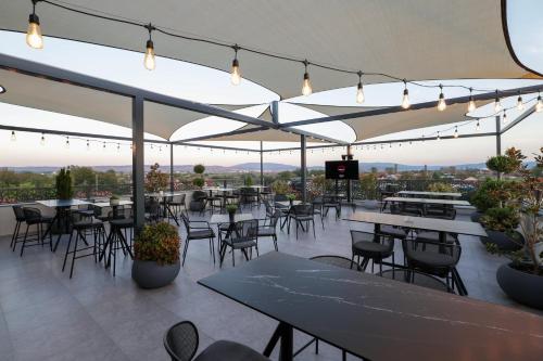 an outdoor patio with tables and chairs and lights at Nest Suites in Skopje