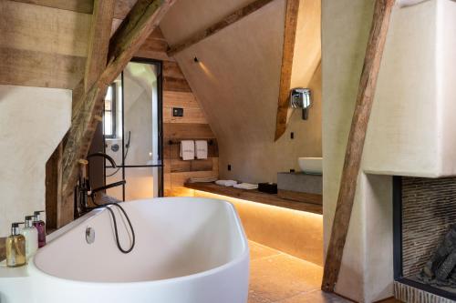 a bathroom with a white tub and a fireplace at La Ferme Saint Simeon Spa - Relais & Chateaux in Honfleur