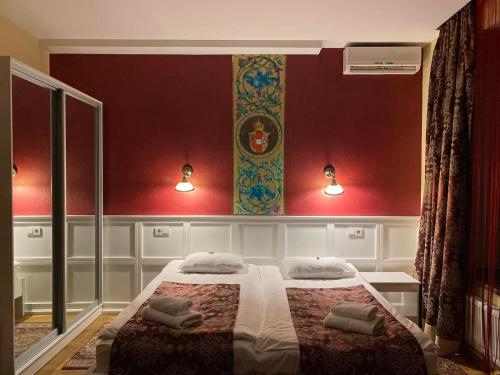 a bedroom with a large bed with red walls at Fontush Boutique Hotel in Ivano-Frankivsʼk
