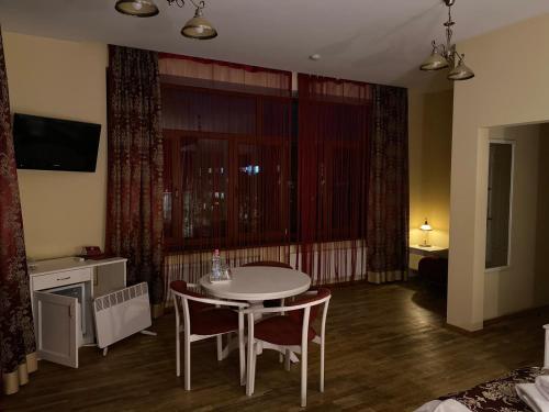 a room with a table and chairs and a bedroom at Fontush Boutique Hotel in Ivano-Frankivsʼk