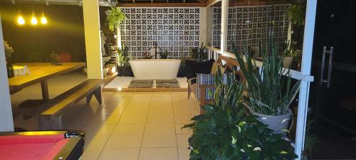 a room with a tub and a table and a plant at Recanto das Orquídeas Domingos Martins- Soido De Cima,4km centro in Domingos Martins