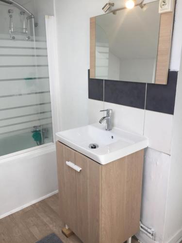 a bathroom with a sink and a mirror at Appart Hotel Le Victor Hugo Art Mechanical et sa pizza offerte in Aurillac